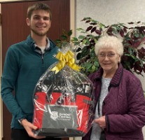 Prize winner holding gift basket.